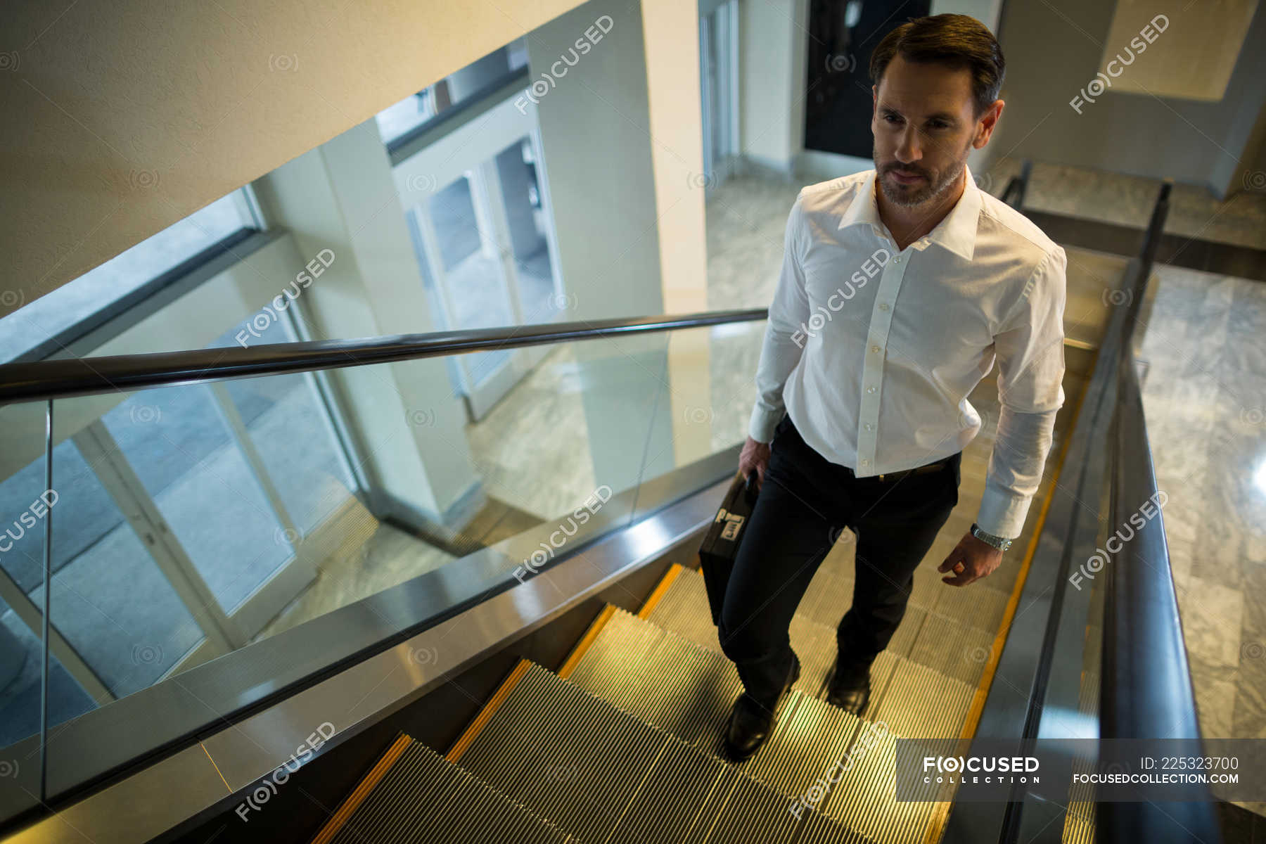 handsome-man-on-escalator-in-airport-airline-staircase-stock-photo