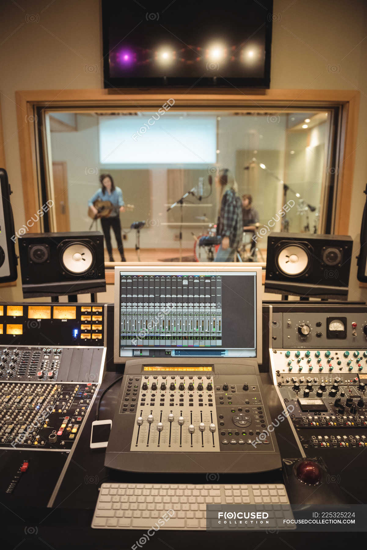 Sound mixer in a recording studio with musicians in background —  electronic, male - Stock Photo | #225325224