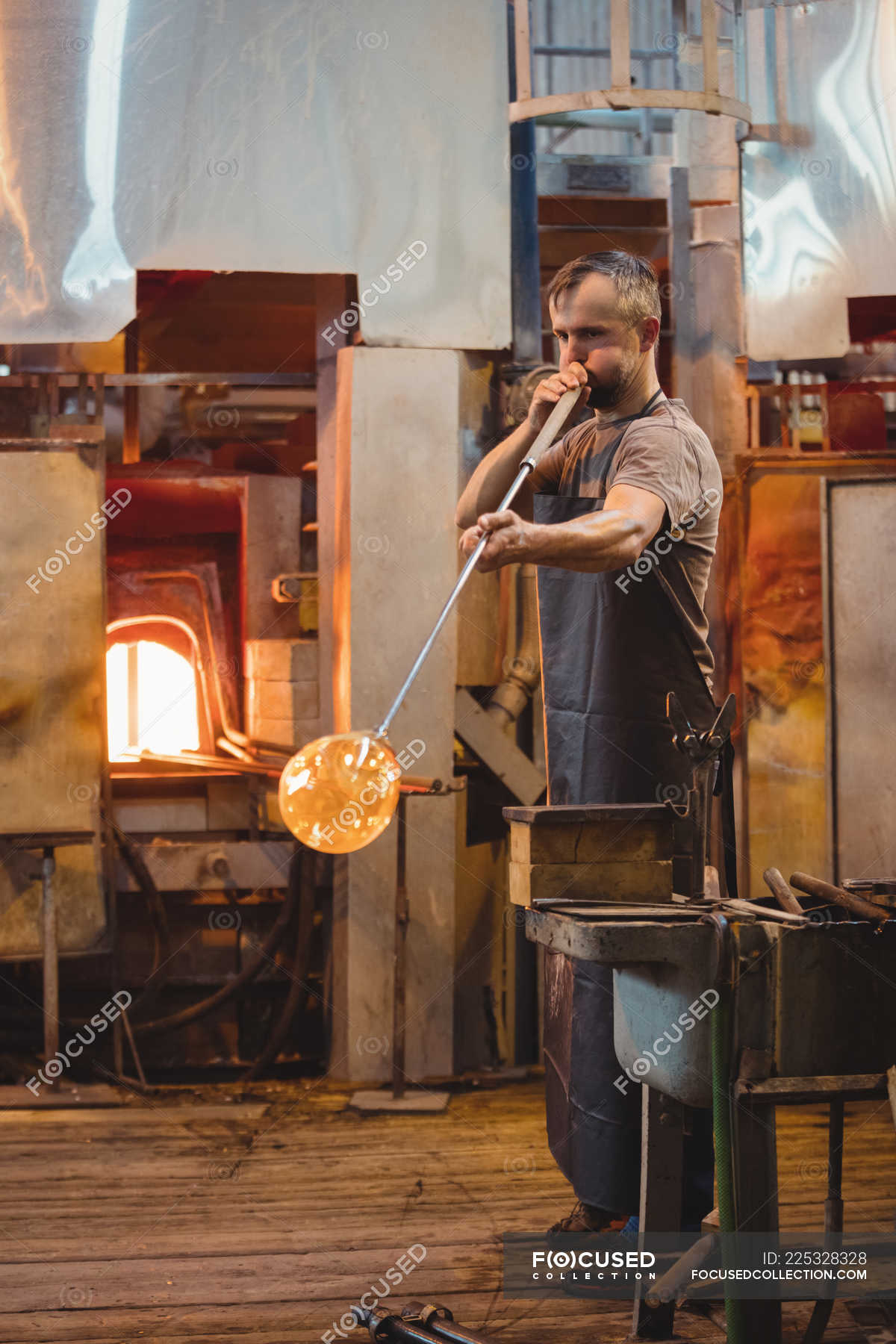 Glassblower Shaping A Glass On The Blowpipe At Glassblowing Factory — Glassmith Making Stock