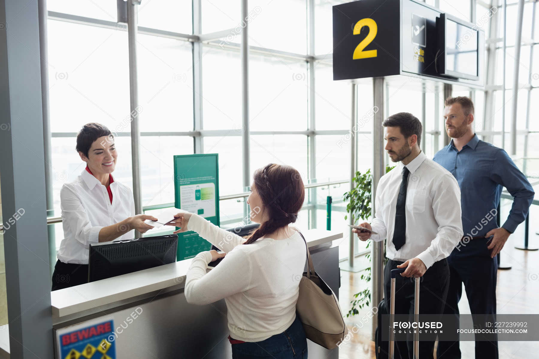 woman-giving-her-passport-to-airline-check-in-attendant-at-airport