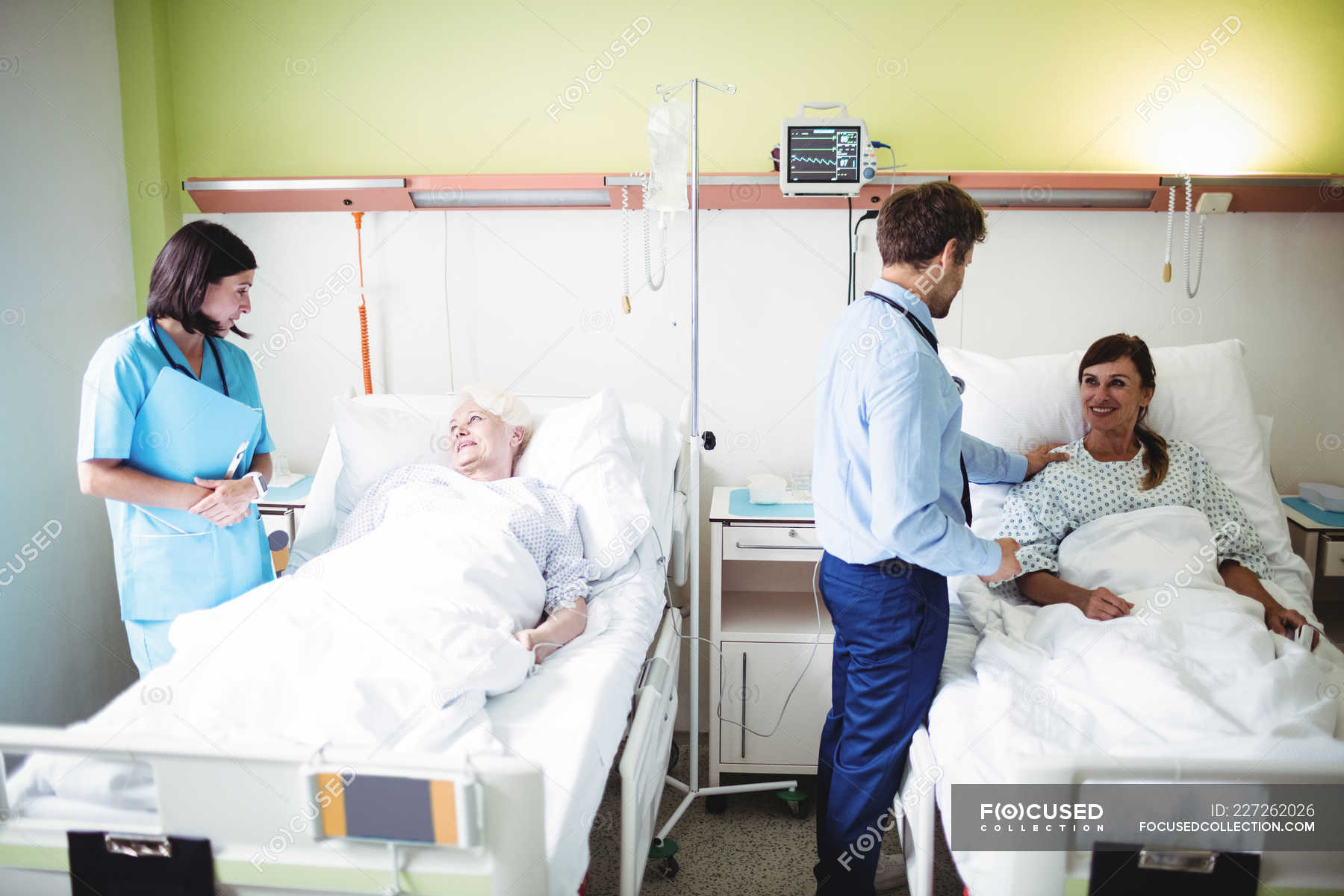 Doctors interacting with patients in hospital ward — professionals, illness - Stock Photo | #227262026