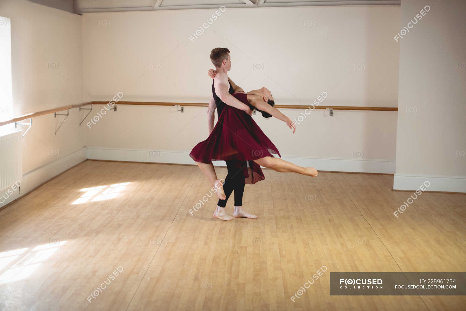 Male and female Ballet partners dancing together in modern studio ...