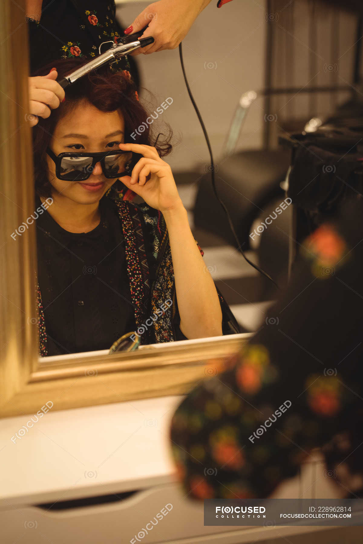 Stylish Woman Looking Over Sunglasses While Getting Her Hair Done At A Professional Hair Salon Feminine Roller Stock Photo