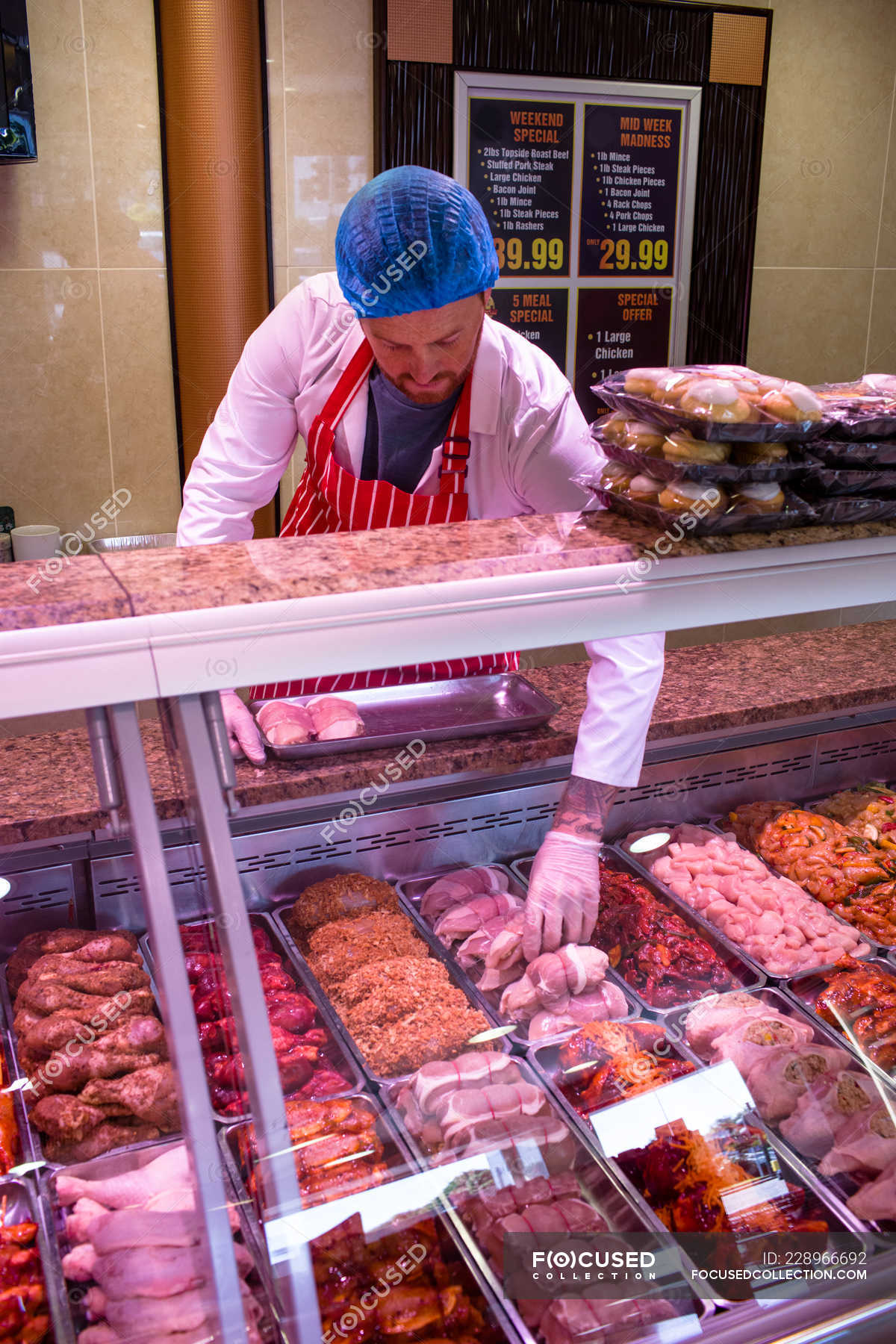 Butcher checking the meat display in butchers shop — fresh, Variety ...
