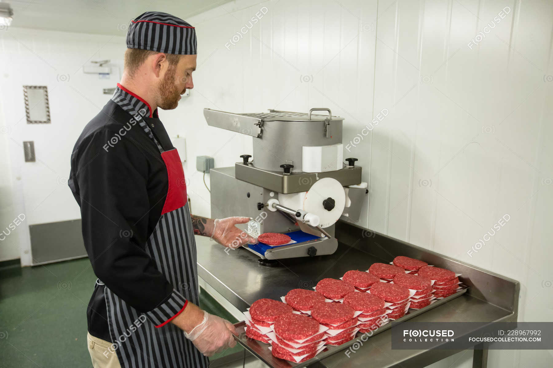 Butcher preparing raw hamburger patties in the butchers shop — uncooked