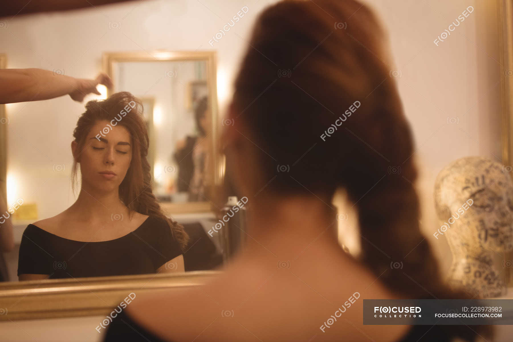 Reflection Of A Beautiful Woman On Mirror Styling Her Hair At