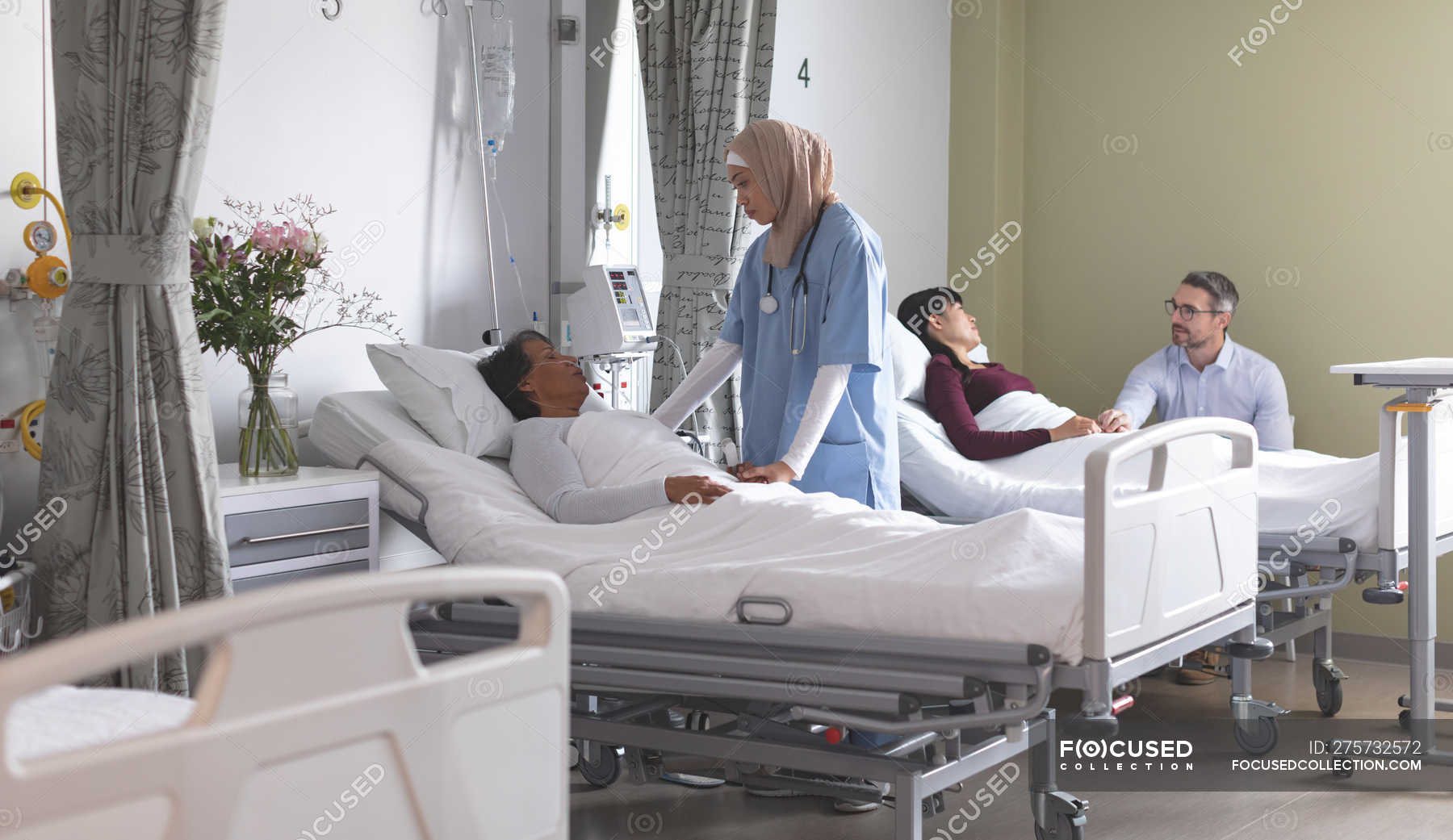 Front view of mixed-race female nurse interacting with mixed-race ...