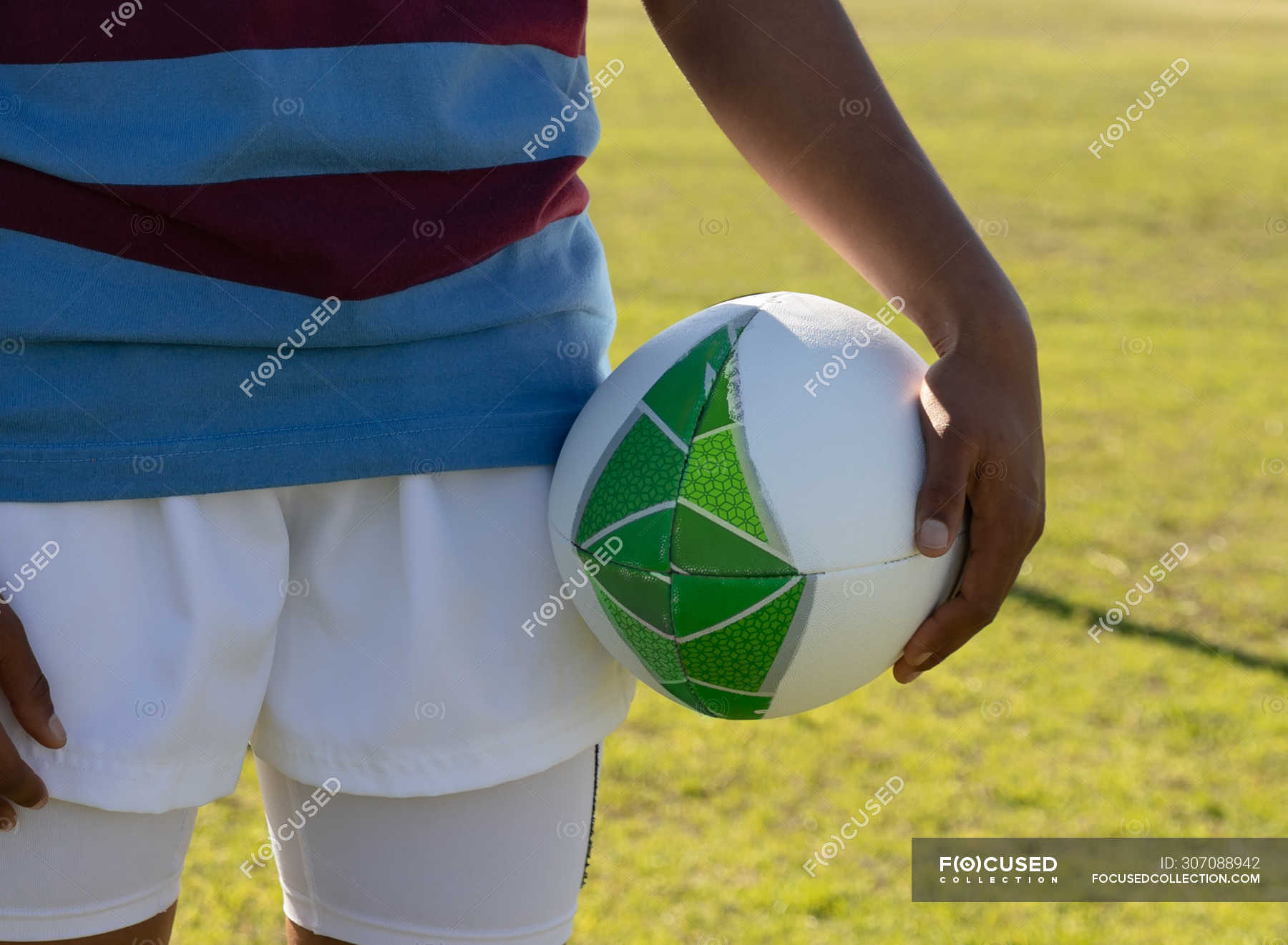 Front view mid section of female rugby player standing on a rugby pitch