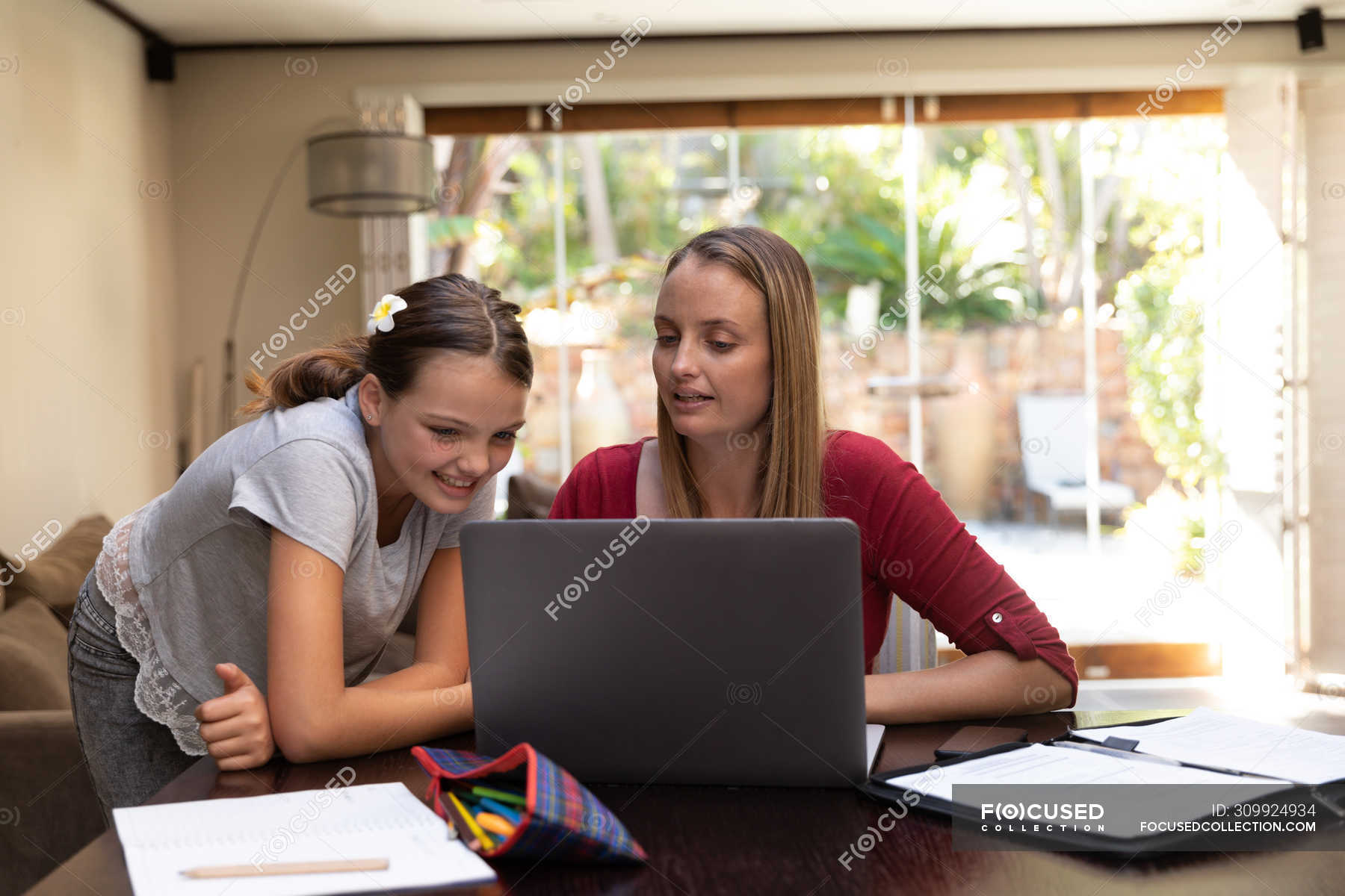 Front view of a young Caucasian woman using a laptop computer with her ...
