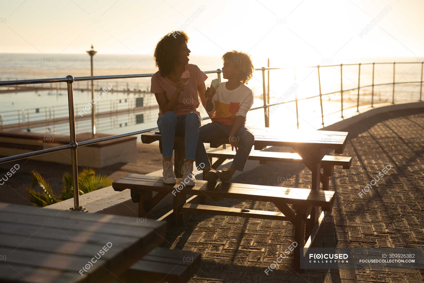 Front view of a mixed race woman and her pre-teen son enjoying time ...