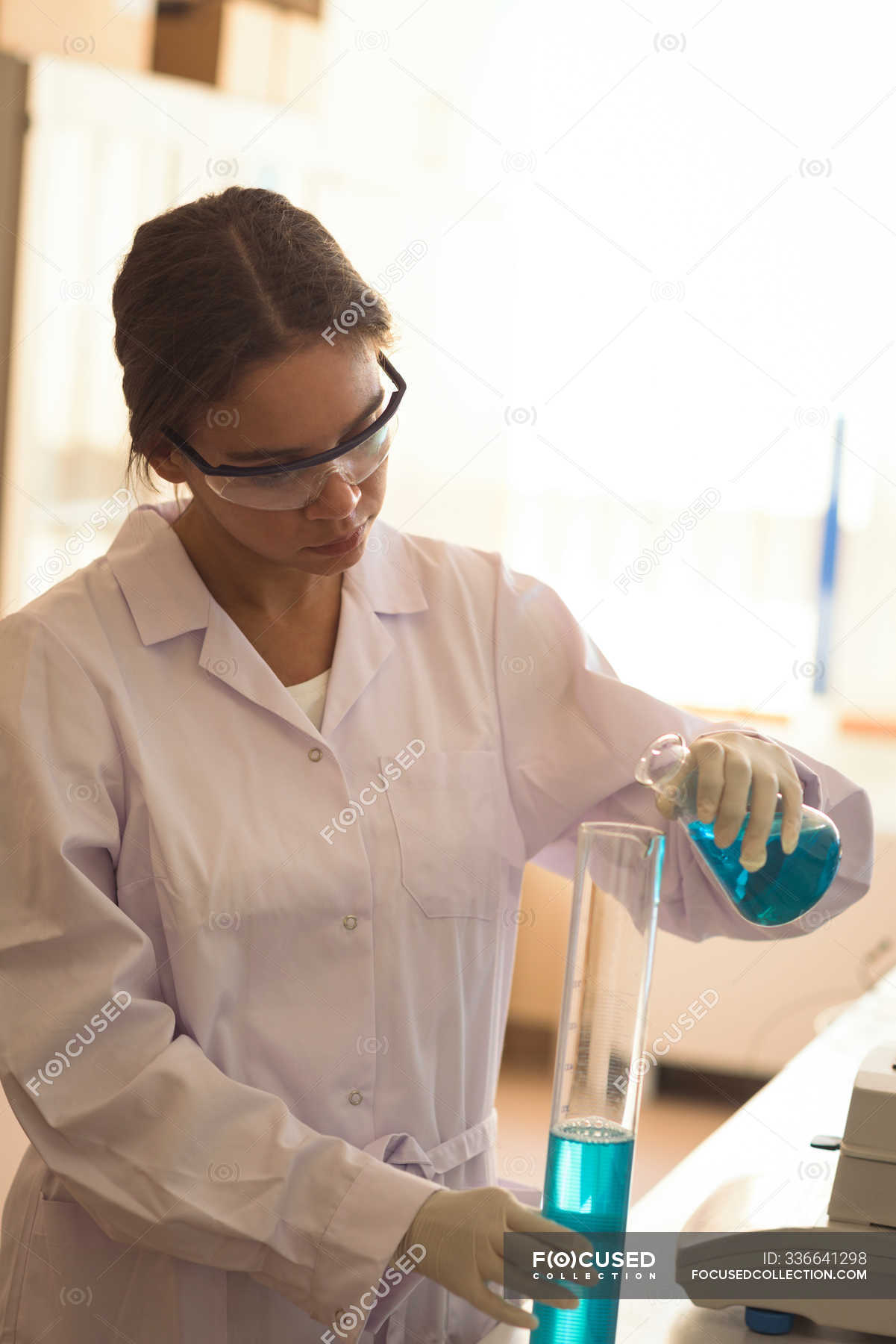 Teenage girl wearing safety glasses while practicing science experiment