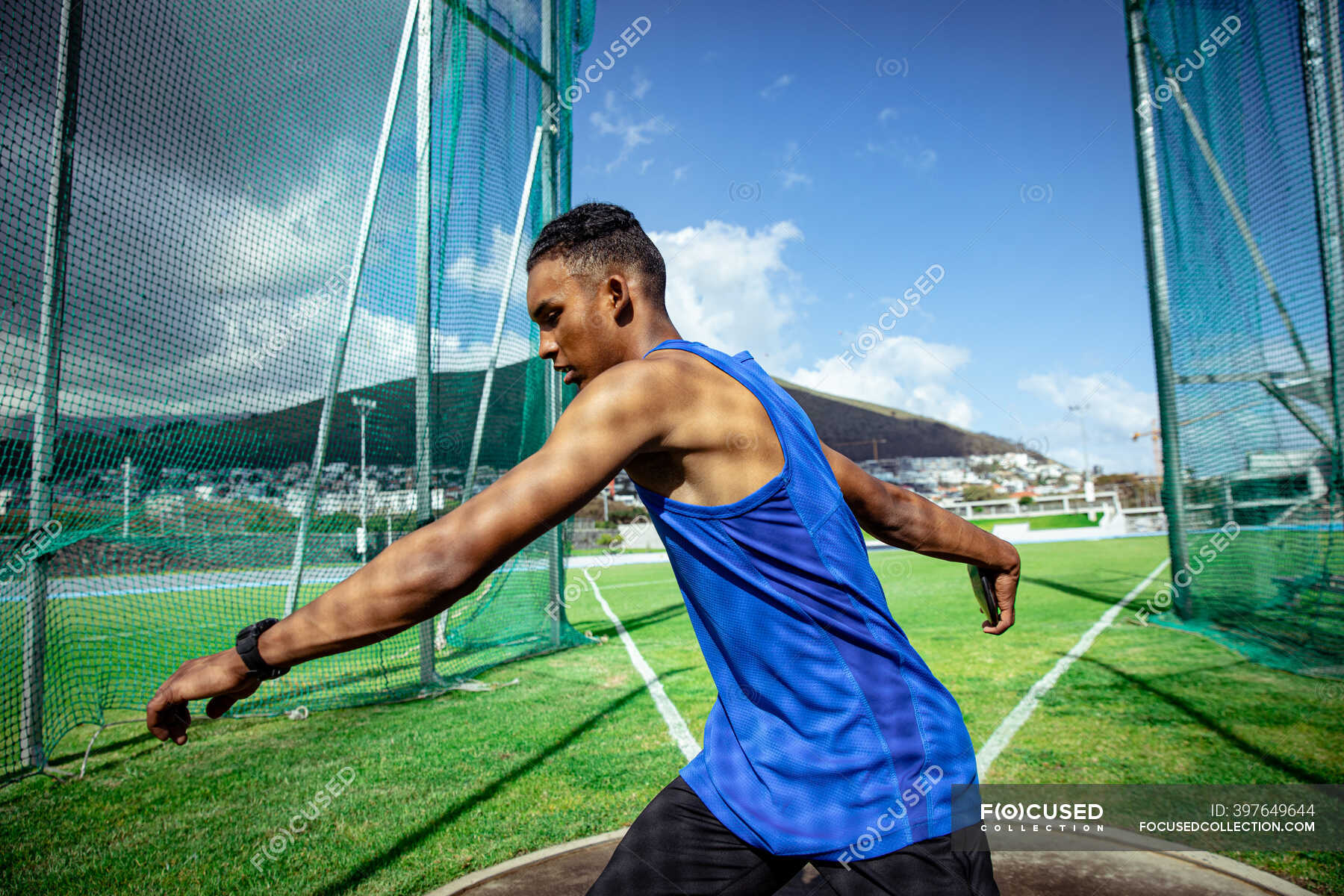 Side View Of A Mixed Race Male Athlete Practicing At A Sports Stadium 