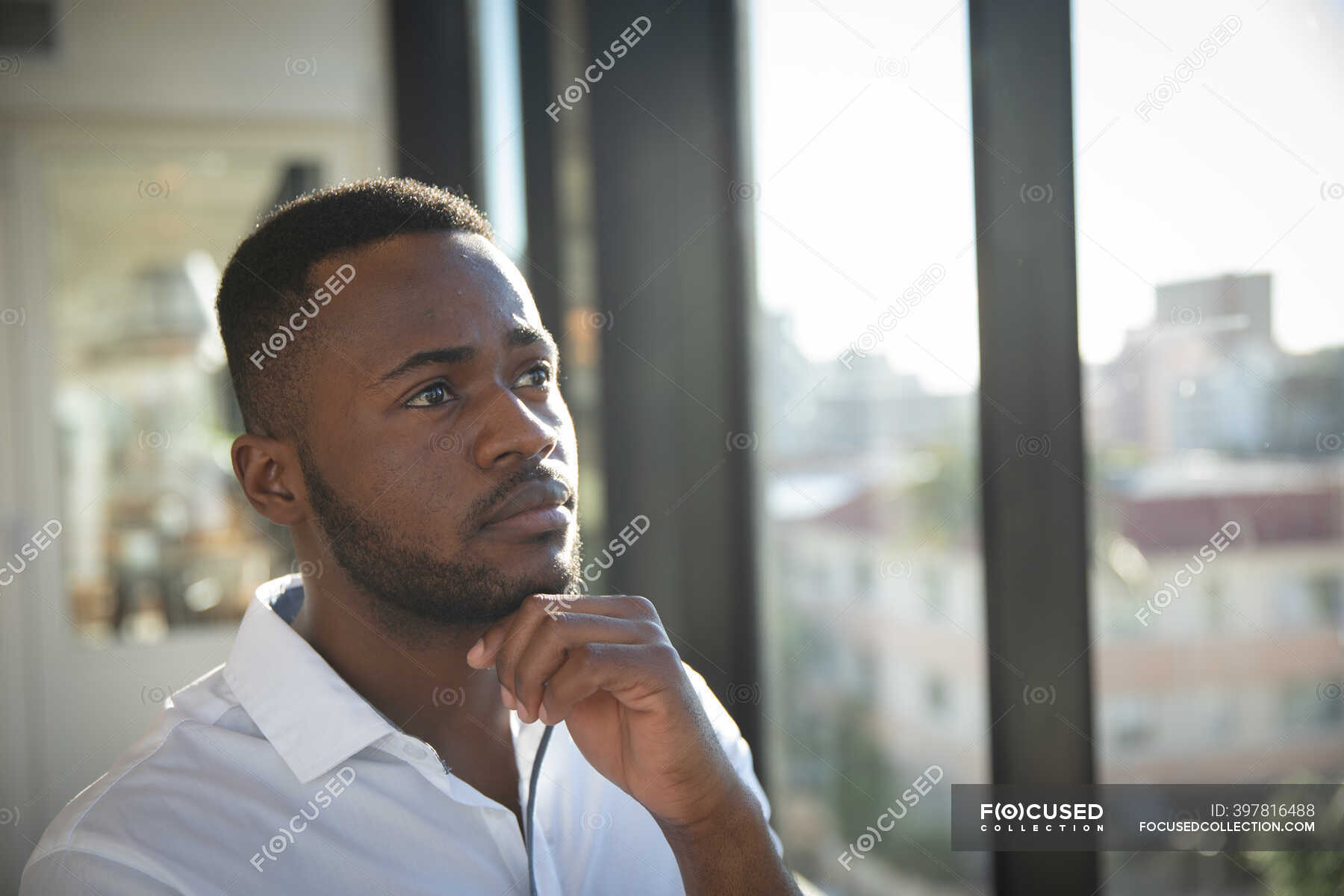 An African American Businessman, Wearing A White Shirt, Working In A 