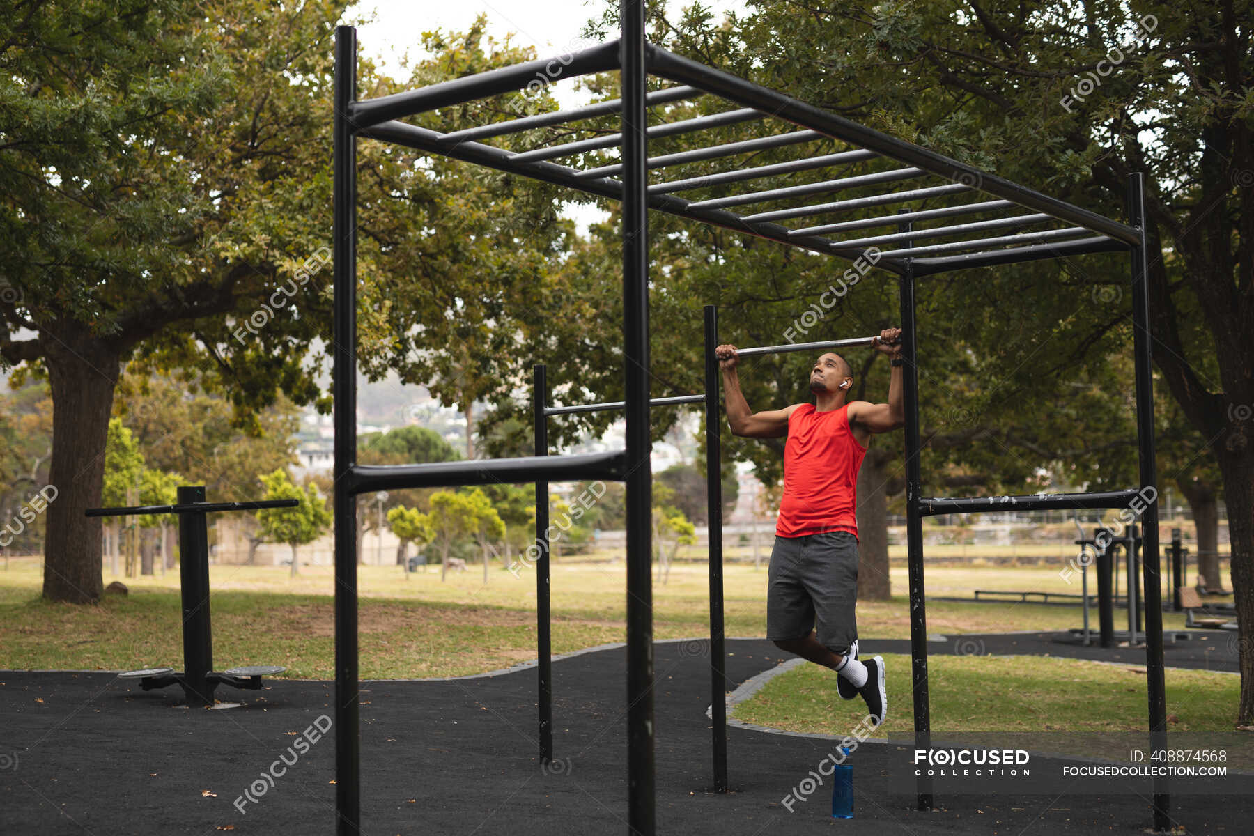 Behinderter Mixed Racer mit Beinprothese, der in einem Park im OutdoorFitnessstudio trainiert Behinderter Mixed Racer mit Beinprothese, der in einem Park im OutdoorFitnessstudio trainiert