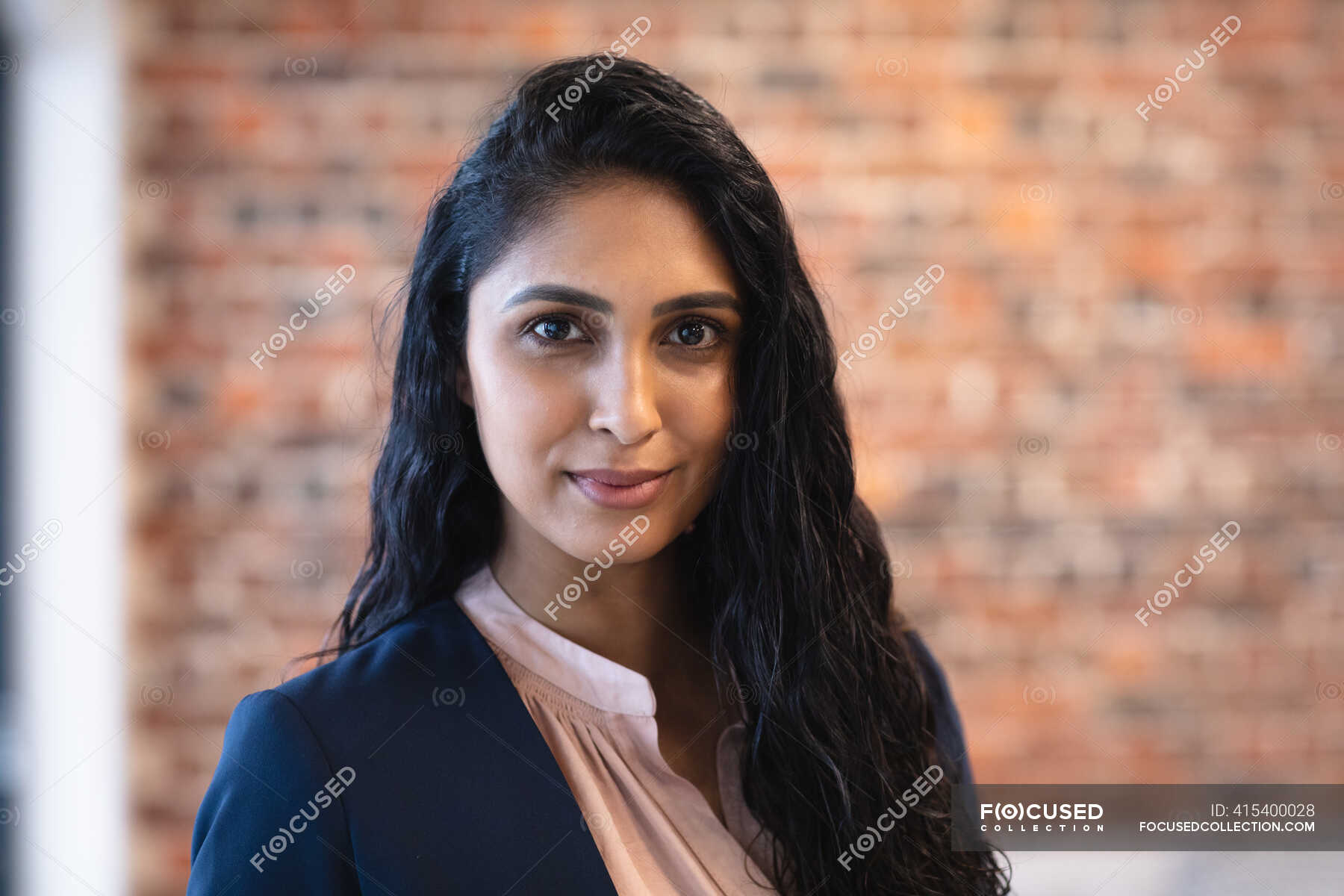 Portrait of mixed race woman working in a casual office, looking at ...