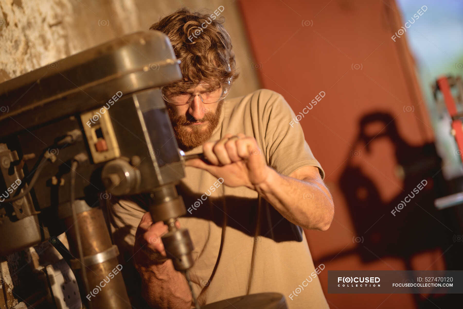 Caucasian blacksmith wearing protective eyewear while working on