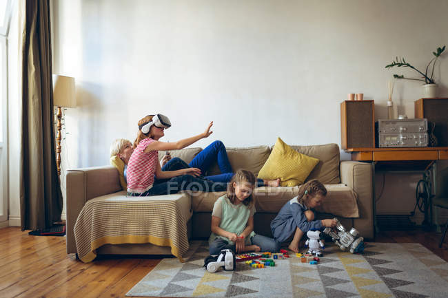 Madre e hijos se divierten en la sala de estar en casa - foto de stock