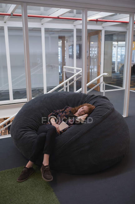 Женщина-руководитель спит на диване в офисе — стоковое фото