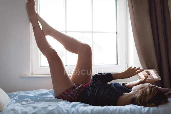 Mulher usando tablet digital no quarto em casa — Fotografia de Stock