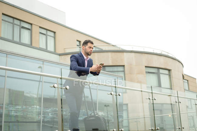 Бизнесмен, использующий мобильный телефон в помещениях отеля — стоковое фото