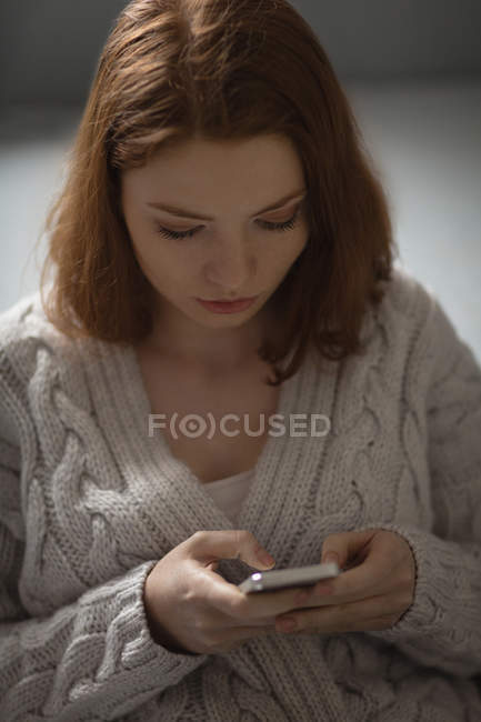 Junge Frau benutzt Handy zu Hause — Stockfoto