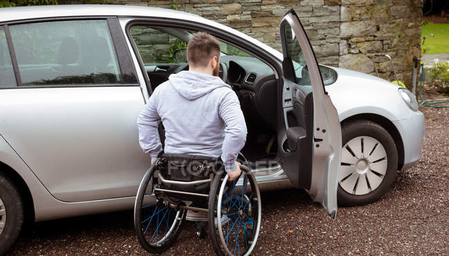 Rear view of disabled man boarding in his car — Stock Photo