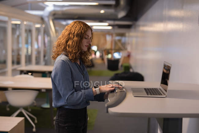 Female executive exercising on treadmill in office — Stock Photo