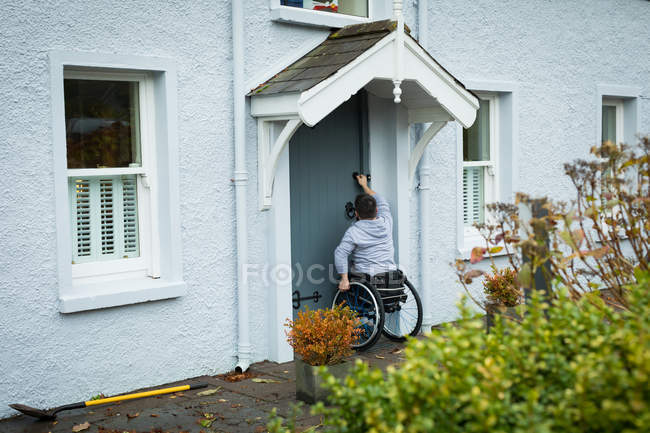 Disabled man opening the door of his home — Stock Photo