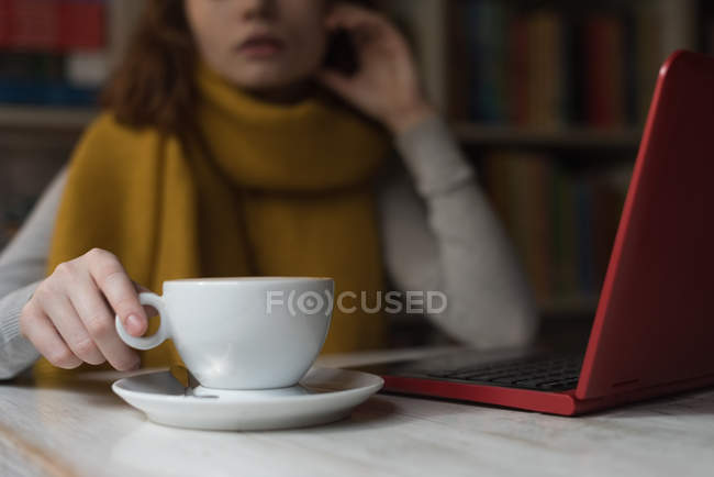 Mid section of woman having dessert in library room — Stock Photo