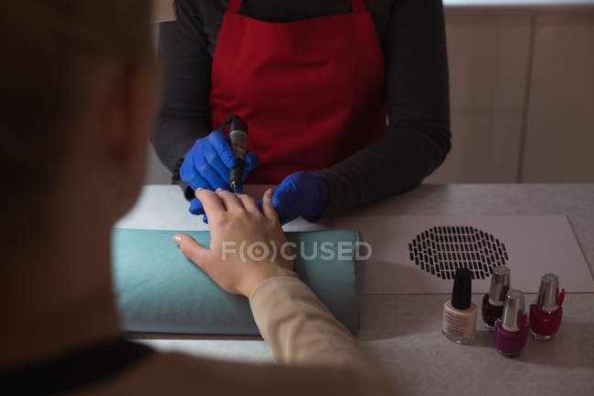 Beautician giving manicure treatment to female customer in parlour — Stock Photo