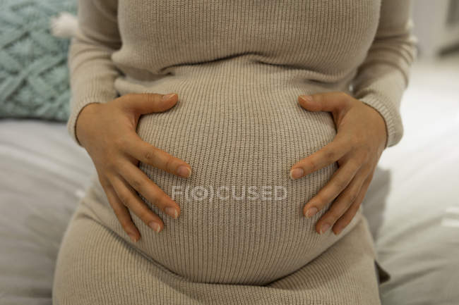 Mid section of wregnant woman touching her belly in store — Stock Photo