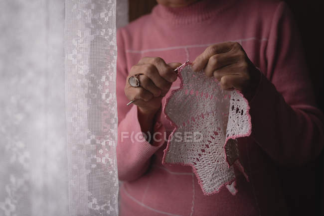 Partie médiane de la femme âgée tricot laine à la maison — Photo de stock