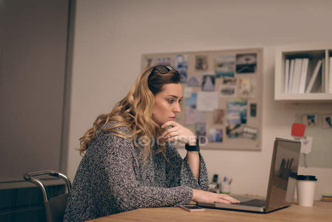 Ejecutivo femenino trabajando en el ordenador portátil en la oficina - foto de stock