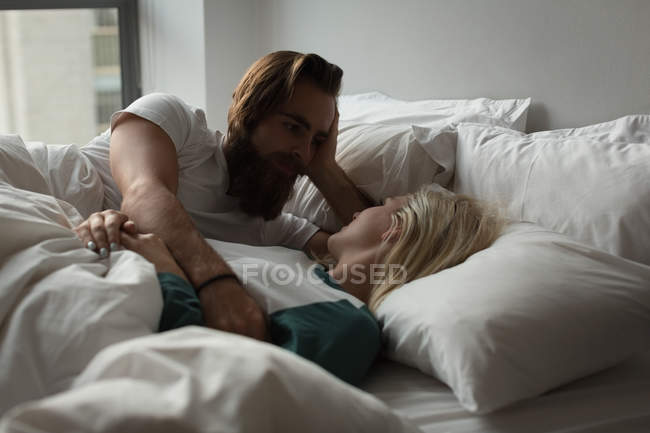 Couple romancing in bedroom at home — Stock Photo