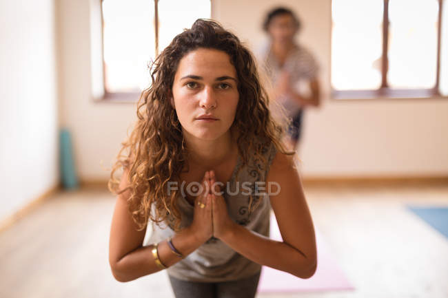 Retrato de mujer realizando ejercicio de yoga en gimnasio - foto de stock