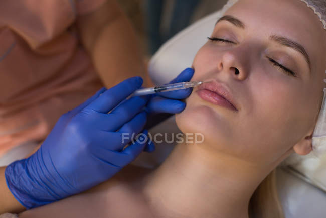 Beautician giving beauty treatment to female customer in parlour — Stock Photo