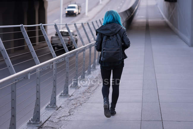 Вид сзади на стильную женщину, идущую по дороге — стоковое фото