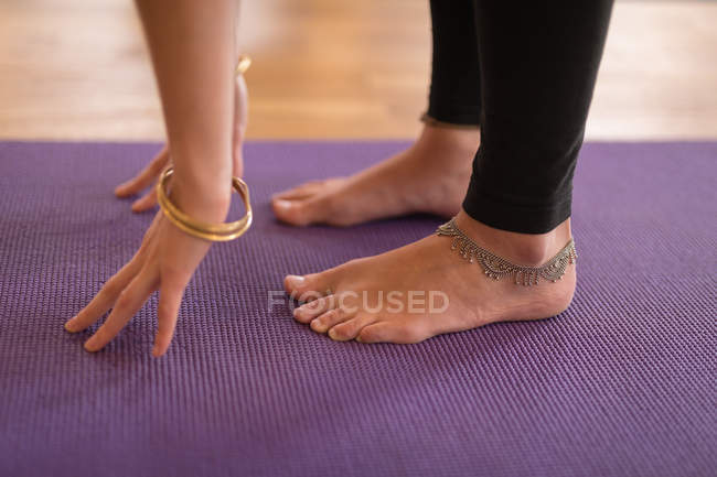 Low section of woman performing yoga exercise in fitness club — Stock Photo
