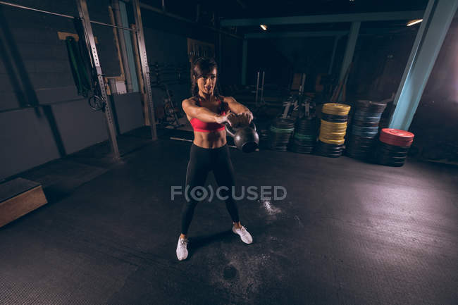 Fit woman exercising with kettlebell in the gym — Stock Photo