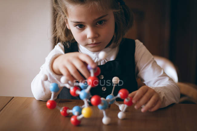 Ragazza sperimentando modello molecolare a casa — Foto stock