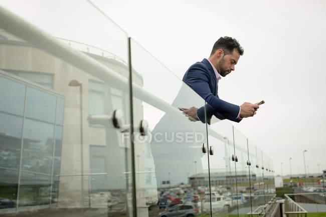 Empresário usando telefone celular nas instalações do hotel — Fotografia de Stock