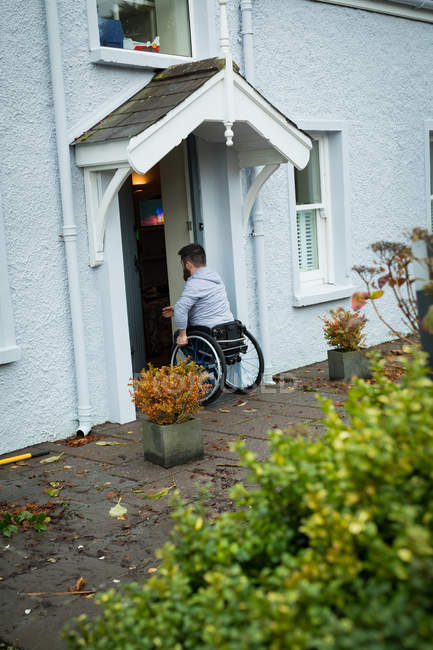 Людина з обмеженими можливостями відкриває двері свого будинку — стокове фото