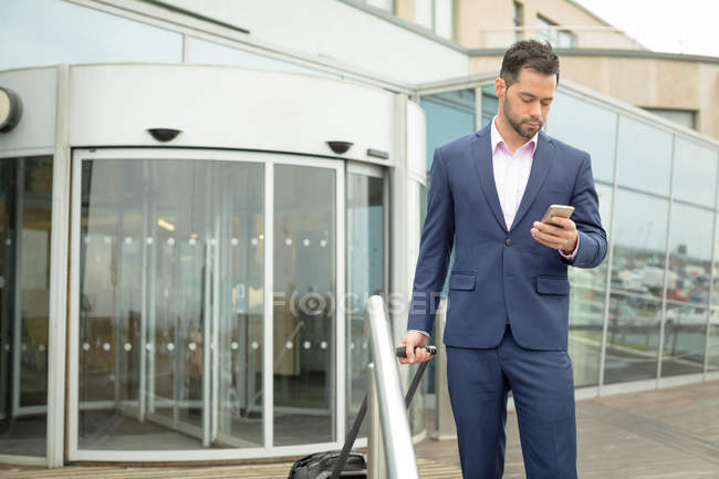 Бизнесмен, использующий мобильный телефон в помещениях отеля — стоковое фото