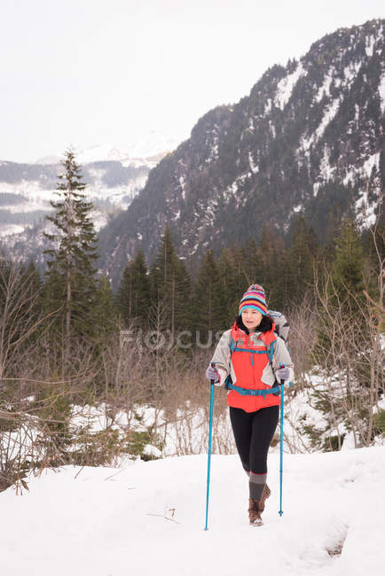 Donna con zaino escursionismo sulla neve durante l'inverno — Foto stock