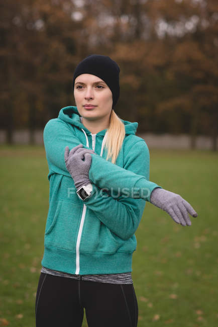 Молодая женщина выполняет упражнения на растяжку в парке — стоковое фото