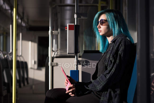Mulher elegante usando tablet digital enquanto viaja no trem — Fotografia de Stock