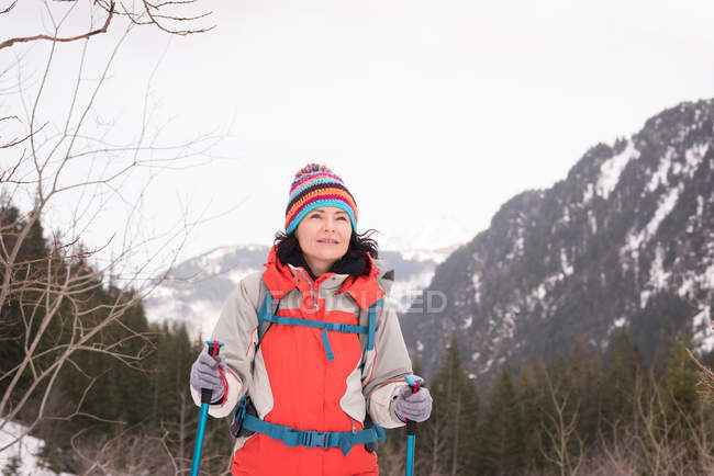 Продумана жінка з рюкзаком, що йде снігом взимку — стокове фото