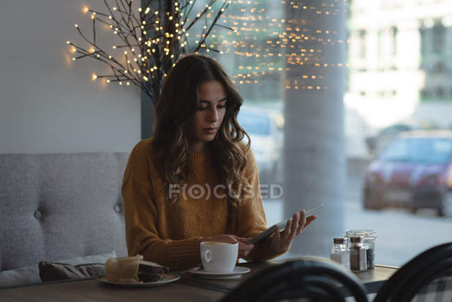 Junge Frau nutzt digitales Tablet in Restaurant — Stockfoto