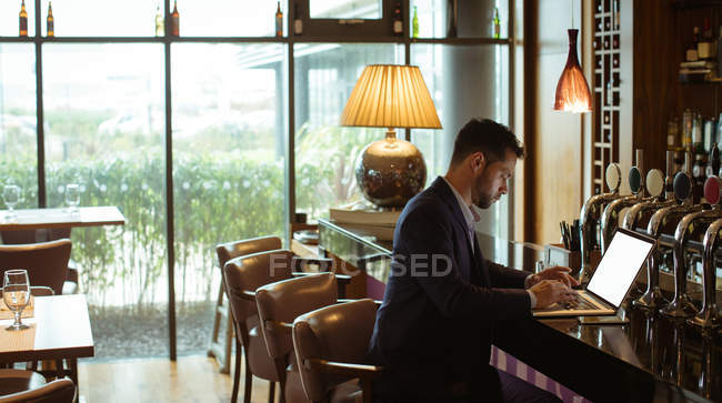 Бизнесмен, использующий ноутбук на стойке регистрации в отеле — стоковое фото