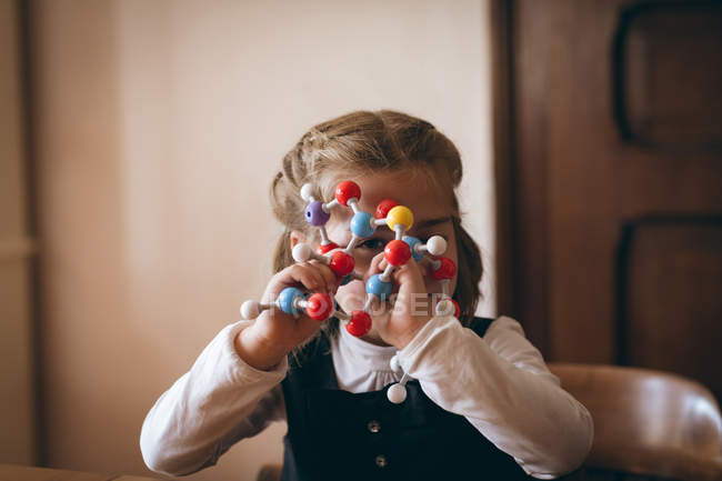 Ragazza guardando attraverso modello molecolare a casa — Foto stock